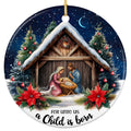 Mary in Pink and Joseph in Blue Kneeling at a Manger Inside a Snow Covered Stable. Ceramic Keepsake.