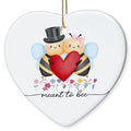 Two Cartoon Bees Holding a Red Heart Above a Row of Wildflowers. Heart-Shaped Ceramic Keepsake for Couples.