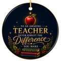 A glossy red apple resting on a stack of three gold-edged books, framed by pine. Ceramic keepsake for classroom teachers
