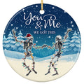 Two Skeletons Dancing Wrapped in Colored Lights Before a Snowy Pine Forest. Ceramic Keepsake for Goth Decor.